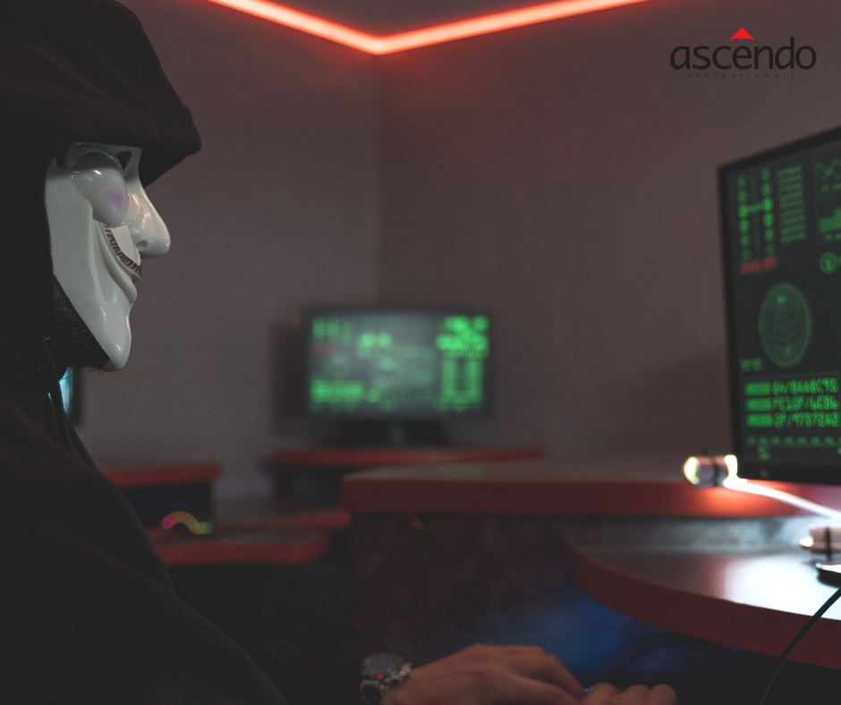 Hacker in dunklem Raum. Er betreibt Cyberangriffe
